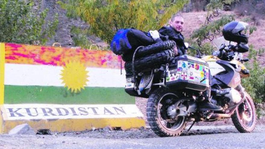 En la foto superior, una vista de la zona antigua de Erbil. Debajo, mujeres y niñas de una familia kurda. Sobre estas líneas, un joven muestra su arma. Abajo, el autor del reportaje, junto a su moto, a punto de pasar la frontera. / miquel silvestre