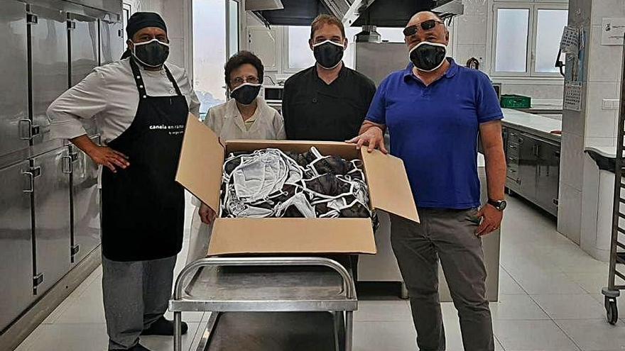 Paco García entrega las mascarillas a los responsables de la Cocina Económica de Oviedo.