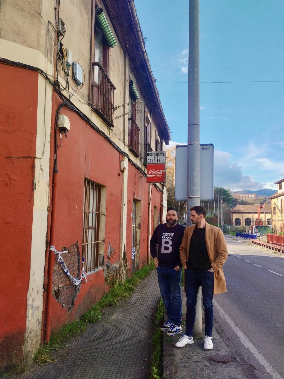 El secretario general del PSOE de Mieres, Alejandro Fernández, y el concejal Jorge Expósito, junto a una vivienda en ruinas.