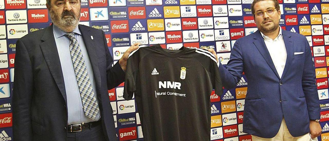 Por la izquierda, Manuel Paredes, presidente en funciones del Oviedo, y Alfredo Navarrete, de NMR, sosteniendo una camiseta de entrenamiento, ayer, en la sala de prensa del Carlos Tartiere.