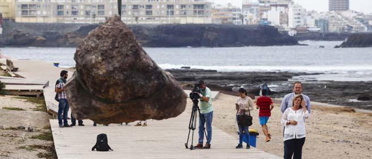 Una de las rocas retiradas por el Ayuntamiento del paseo de El Confital, ayer. A la derecha, los ediles Medina y Ramírez.