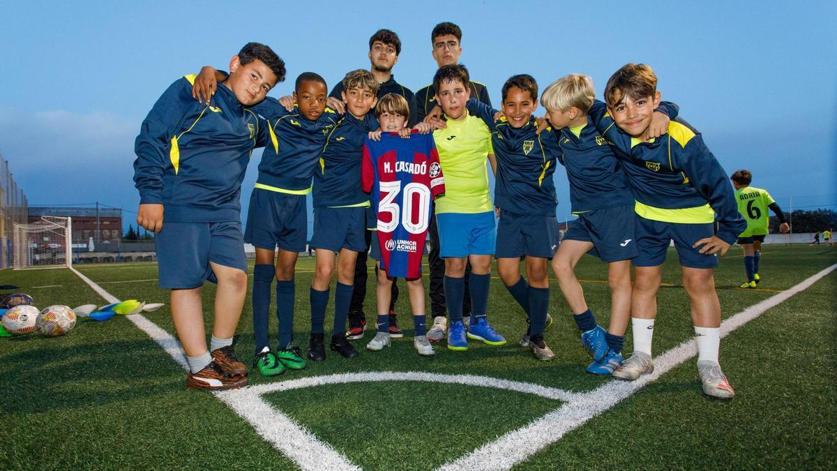 Niños del Benjamín A del Sant Antoni de Vilamajor, con sus entrenadores, con la camiseta de Marc Casadó.