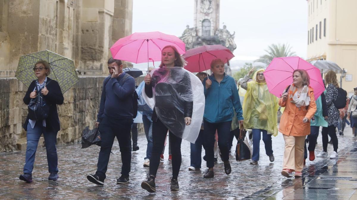 Turistas sostienen sus paraguas en el entorno de la Mezquita de Córdoba.