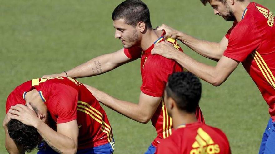 Morata, en el centro, bromea con un compañero en la sesión de entrenamiento de ayer. // Efe