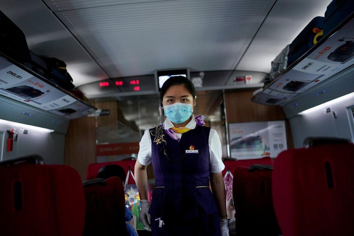 FILE PHOTO: A train staff member walks on a high-speed train at Wuhan Railway Station, in Wuhan, the Chinese city hit the hardest by the coronavirus disease (COVID-19) outbreak, in the Hubei province, China, May 17, 2020. REUTERS/Aly Song/File Photo