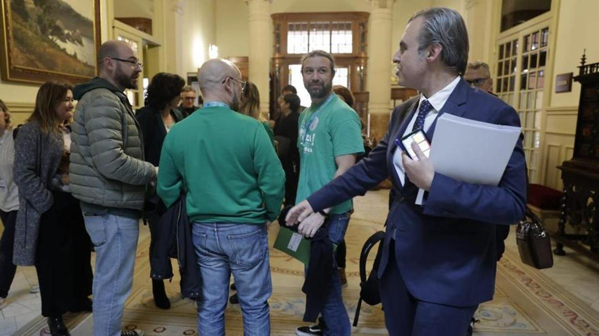 Antoni Vera a su llegada al Parlament saludando a algunos de los asistentes con camisetas verdes GUILLEM BOSCH