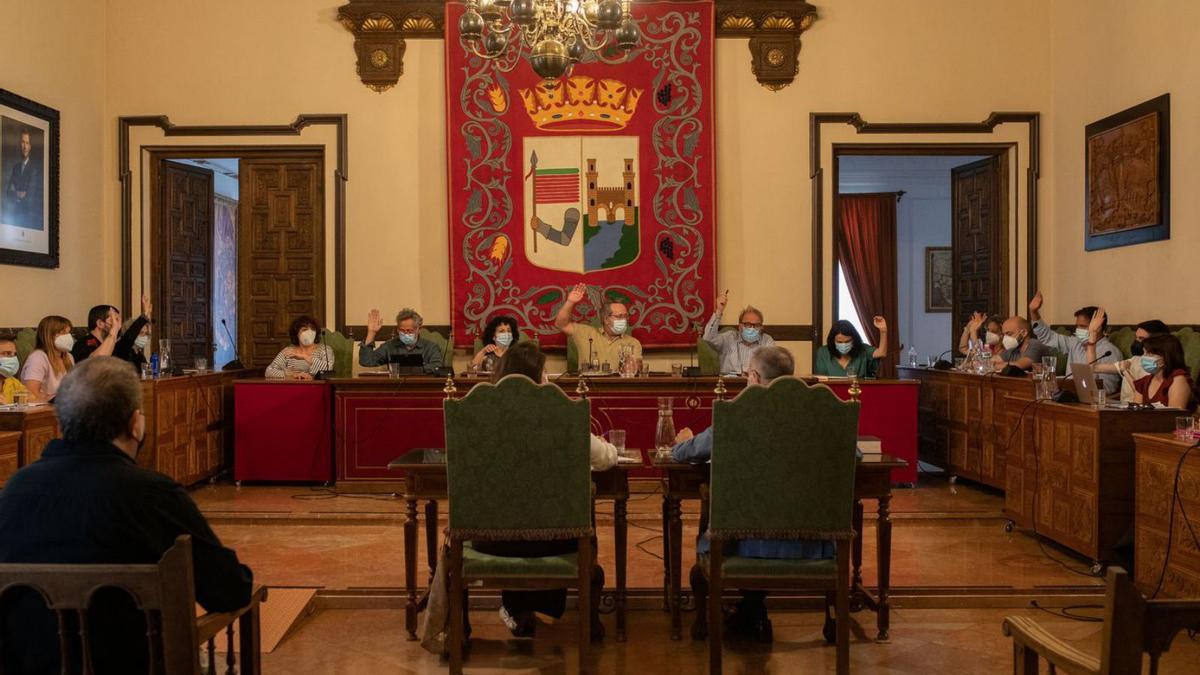 Interventora y secretario, de espaldas, en el centro del salón de plenos del Ayuntamiento de Zamora.