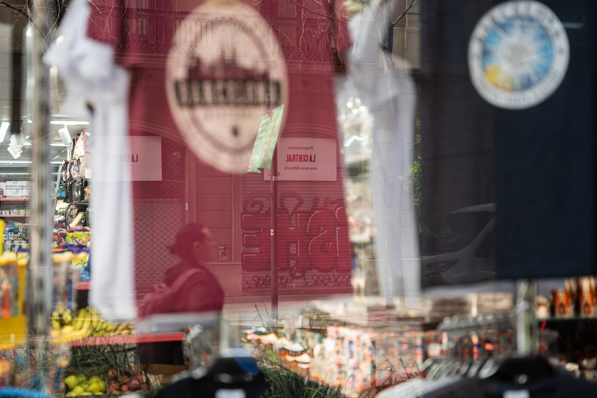 El escaparate del supermercado de la acera contraria, con el reflejo de los carteles de La Central en el cristal.
