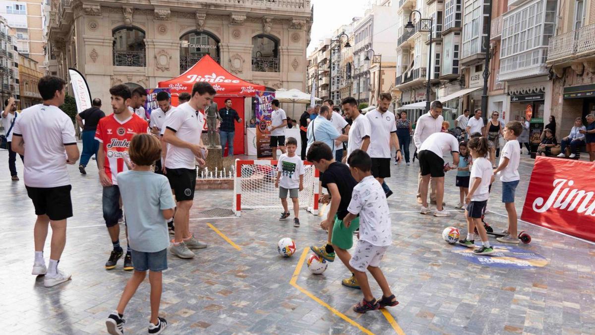 Niños jugando en la Plaza del Icue con los jugadores de la primera plantilla. | PRENSA JIMBEE CARTAGENA