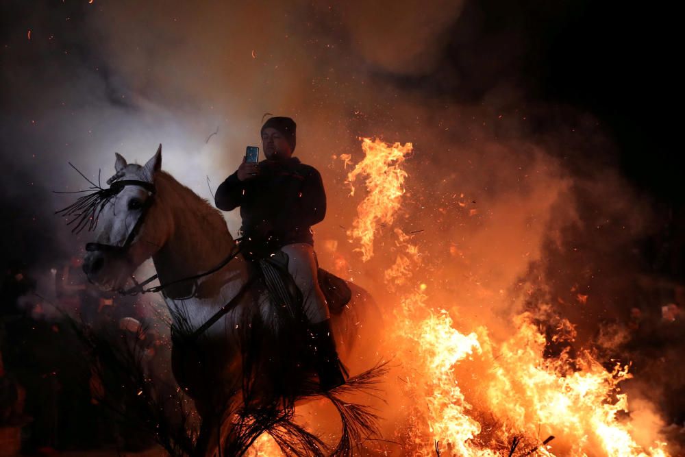 A man points a phone to himself riding a horse ...