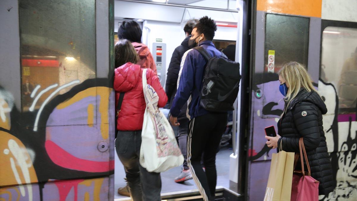 Gente con mascarilla sube a un tren de Rodalies en la estación de plaza de Catalunya.