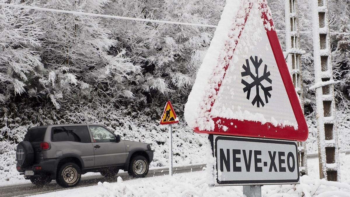Un automóvil circula por una carretera de la montaña lucense tras las copiosas nevadas caídas el pasado fin de semana