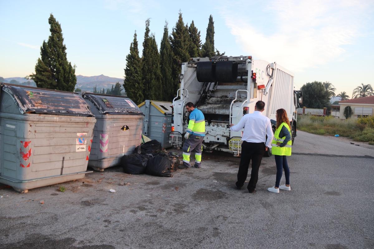 Un operario recoge bolsas de basura dejadas a los pies de un contenedor