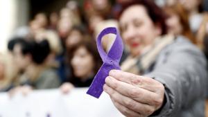 Una mujer sostiene un lazo morado en una manifestación del 8 de marzo por la igualdad en Bilbao.