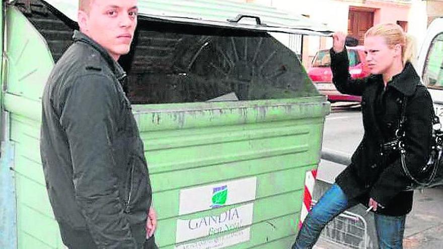 La hermana de la fallecida y su marido mirando un contenedor.