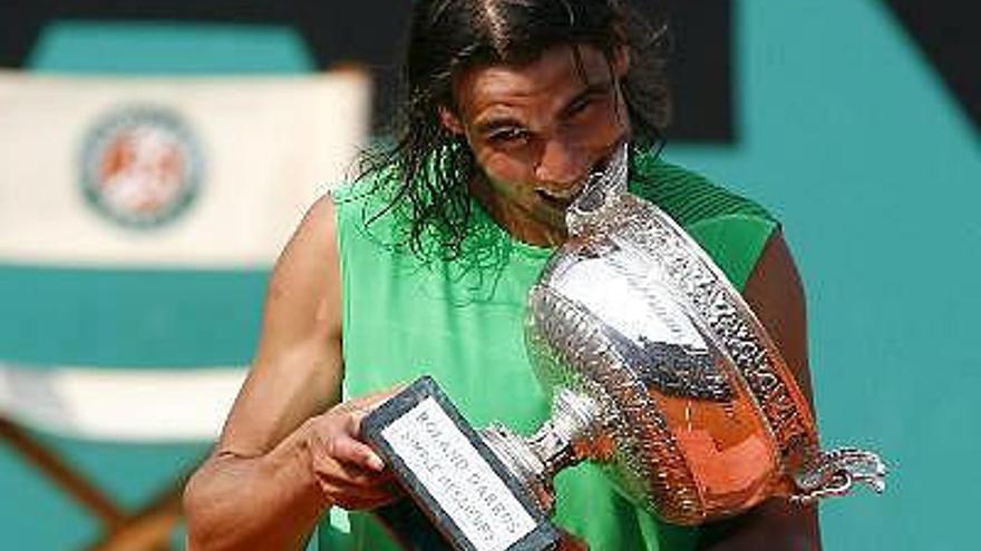 El tenista español Rafael Nadal muerde el trofeo de campeón tras vencer al suizo Roger Federer en la final del torneo Roland Garros que se ha disputado en París, Francia.