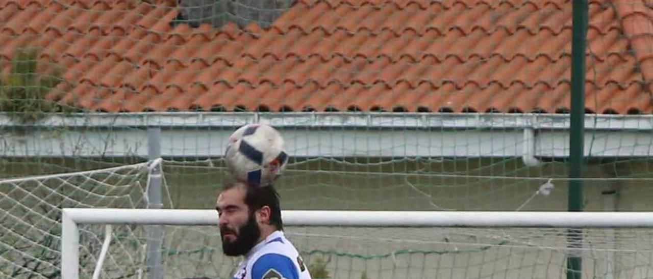 Marcos, del Stadium, salta por un balón con un jugador del Narcea.