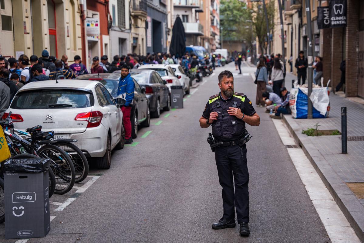Caos y una larga cola de personas que esperan regularizar su situación en España en la Oficina de Benestar Social i Família de Barcelona-Sants/Eixample.