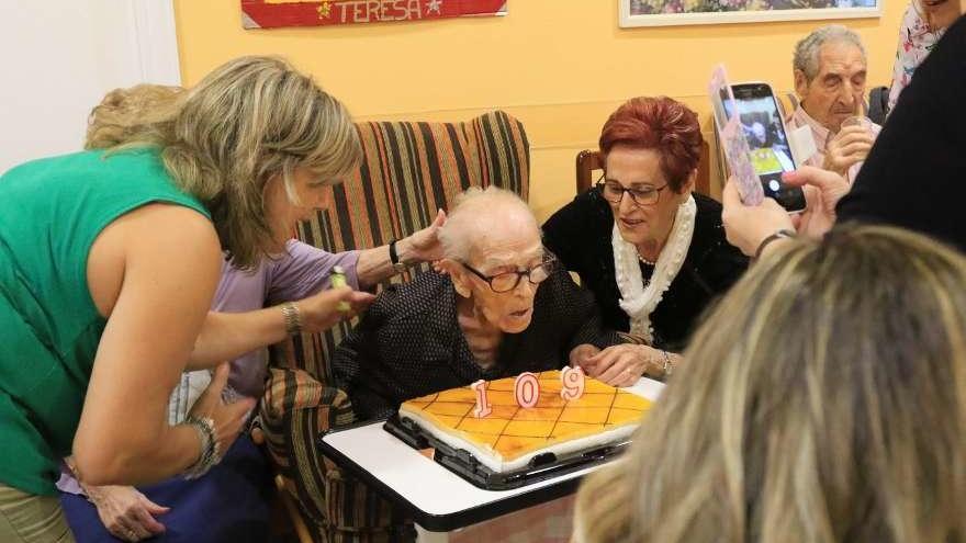 Teresa soplando las velas de su cumpleaños junto a sus hijas.