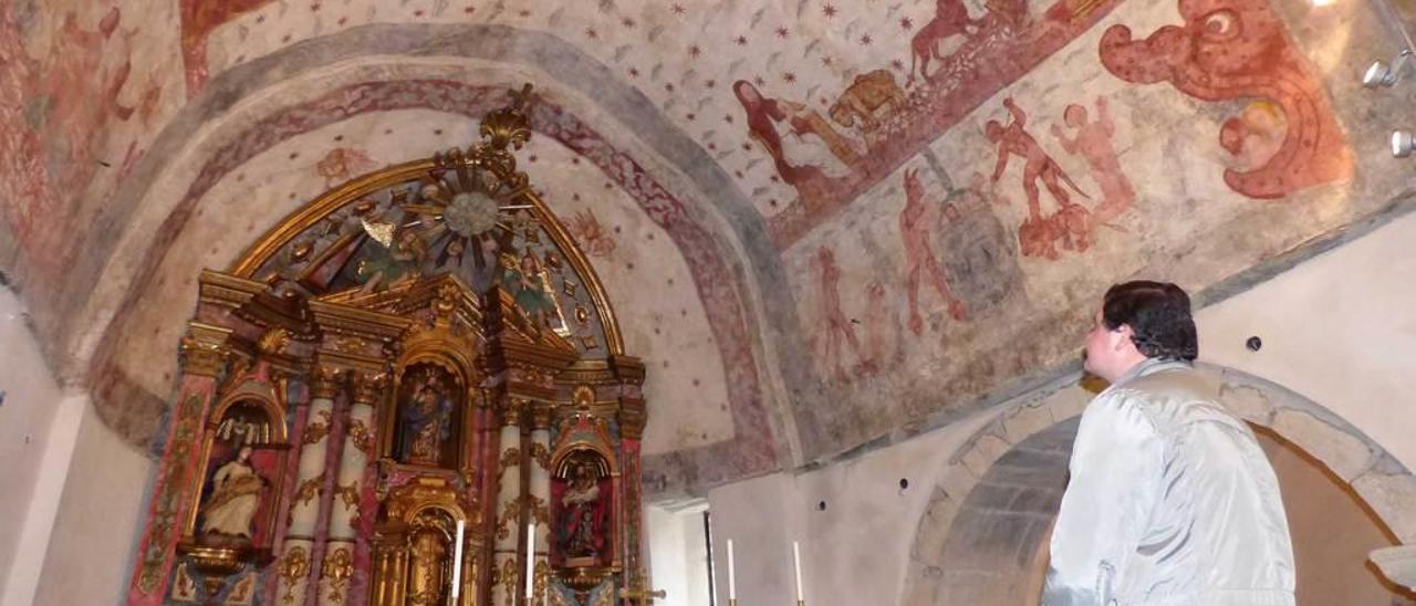 El sacerdote Juan José Blanco admira las pinturas y el retablo de la iglesia de San Salvador de Cibuyo.