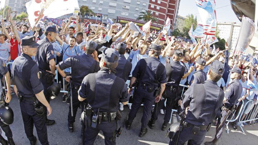 La policía vigila a los aficionados que esperan la llegada del equipo a Balaídos. // Marta G. Brea