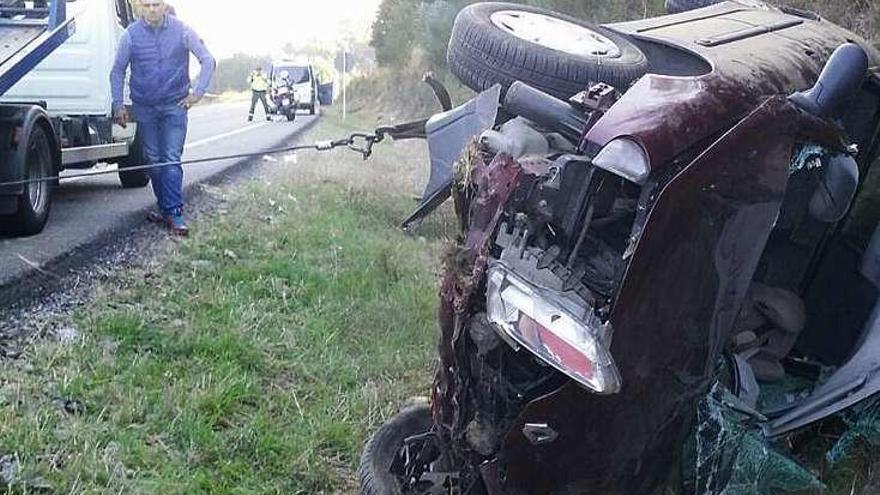 El vehículo de la accidentada, remolcado por una grúa. // FdV