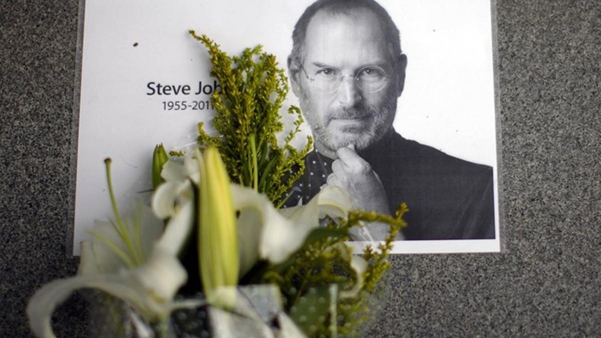 Flores ante un retrato de Steve Jobs, en una plaza de Shanghái.