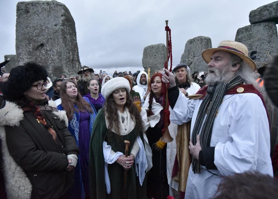 Miles de personas, varias de ellas disfrazadas de druidas, acudieron hoy al monumento de Stonehenge en Inglaterra para ver el amanecer con motivo del solsticio de invierno.