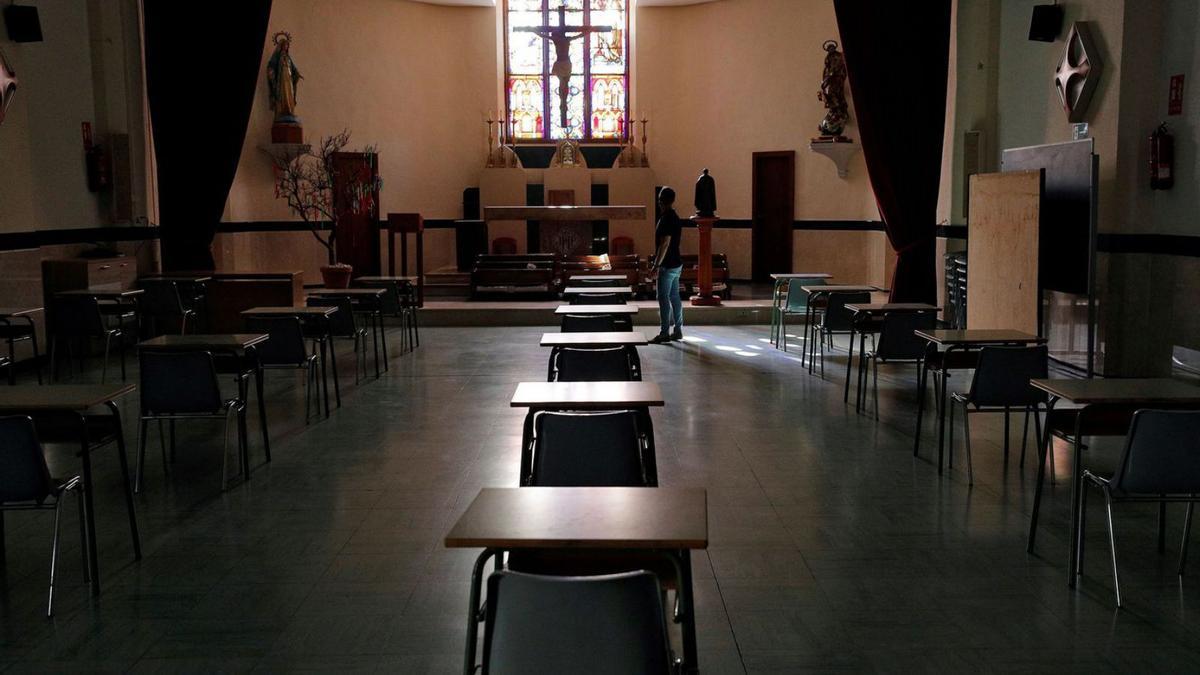 Foto de archivo de una capilla con pupitres, en un centro educativo de València. | EFE/MANUEL BRUQUE