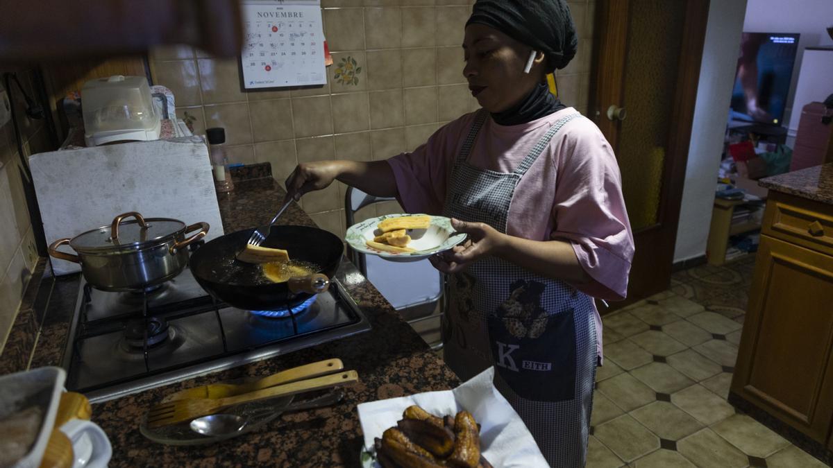 Olga, una madre soltera que no recibe el bono térmico, cocina en su casa de València