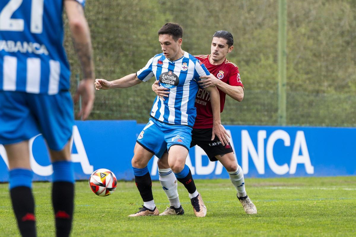 Mario Nájera protege el balón ante un jugador de la Gimnástica.