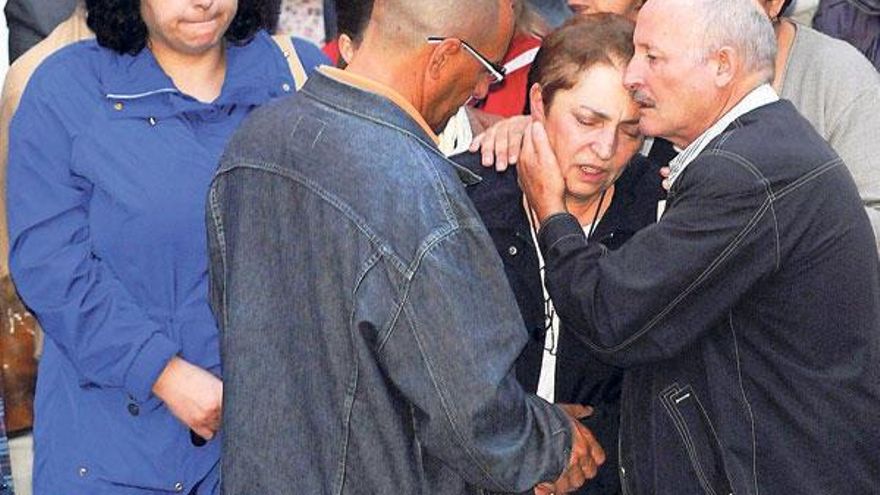 El cuñado de Sonia Iglesias (de espaldas) intenta consolar a los padres de la desaparecida.  // Rafa Vázquez