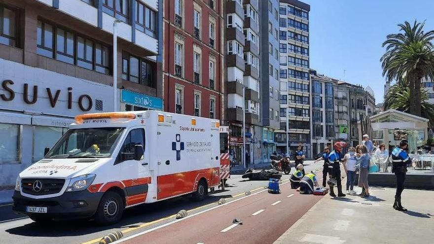 Los sanitarios y la Policía, ayer, atendiendo al motorista, tendido en el carril bici de los Jardines de la Reina, en Gijón.