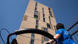 Una vecina junto a un bloque de edificios de protección oficial en Barcelona.