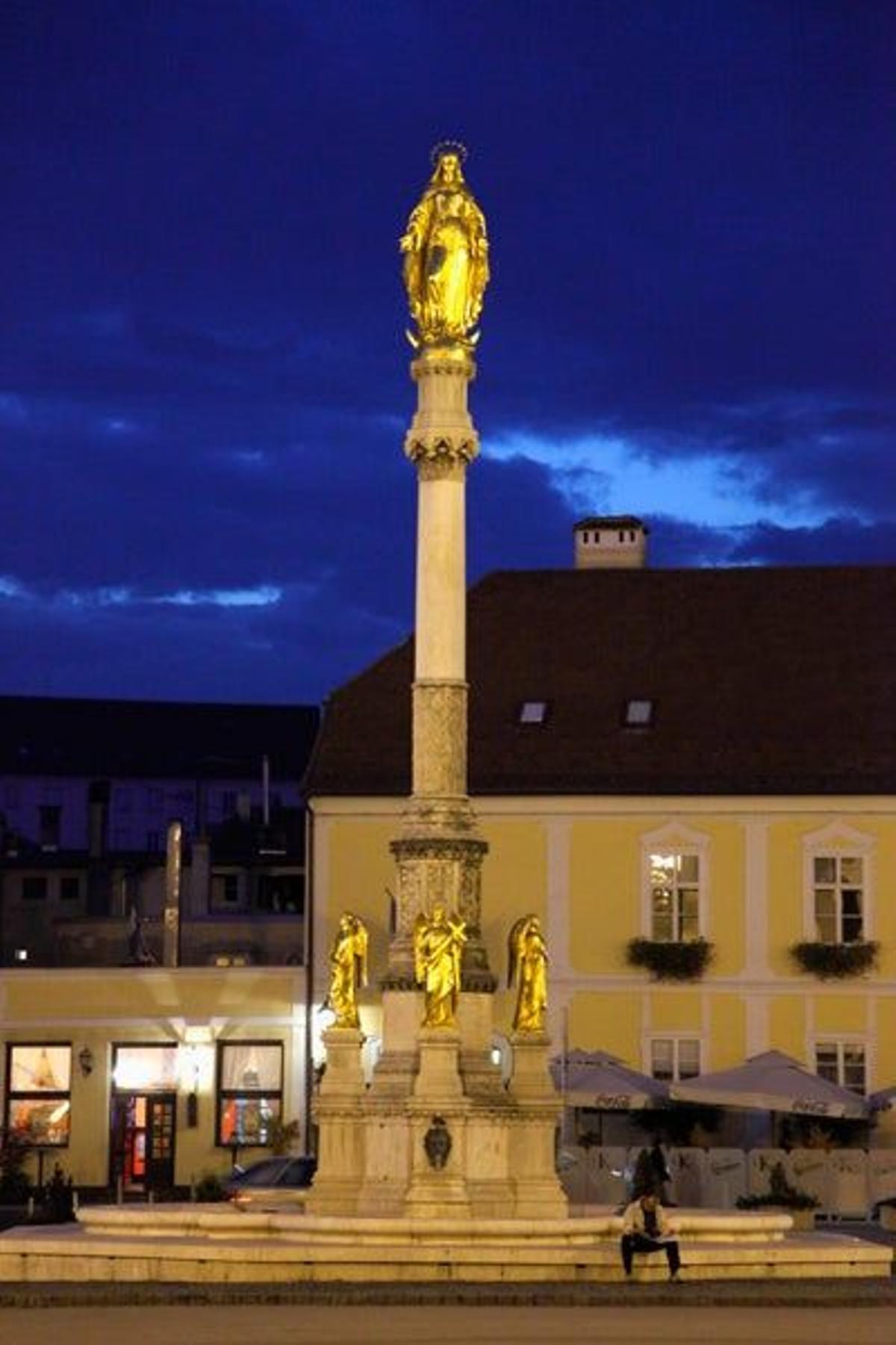 Plaza Kaptol con una estatua dorada en el centro dedicada a la Virgen María.