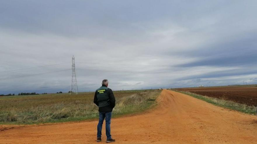 Un guardia civil vigila el camino donde se produjo el ataque mortal.