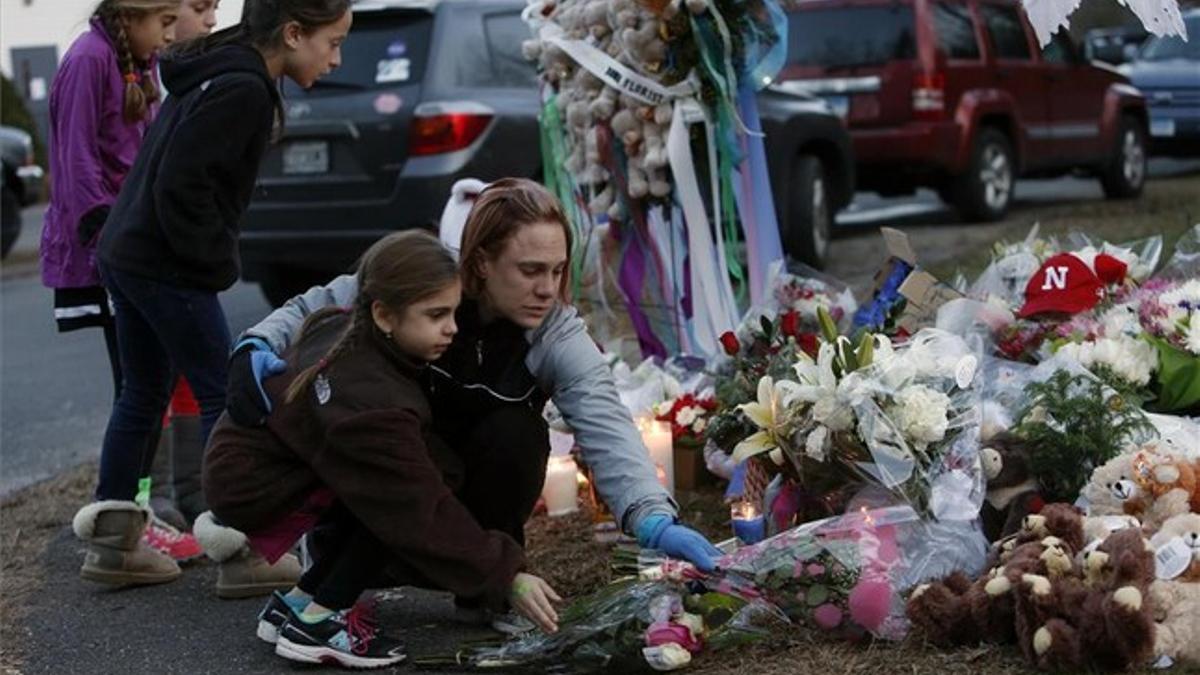 Un grupo de niñas deja una ofrenda floral en memoria de las víctimas del tiroteo.