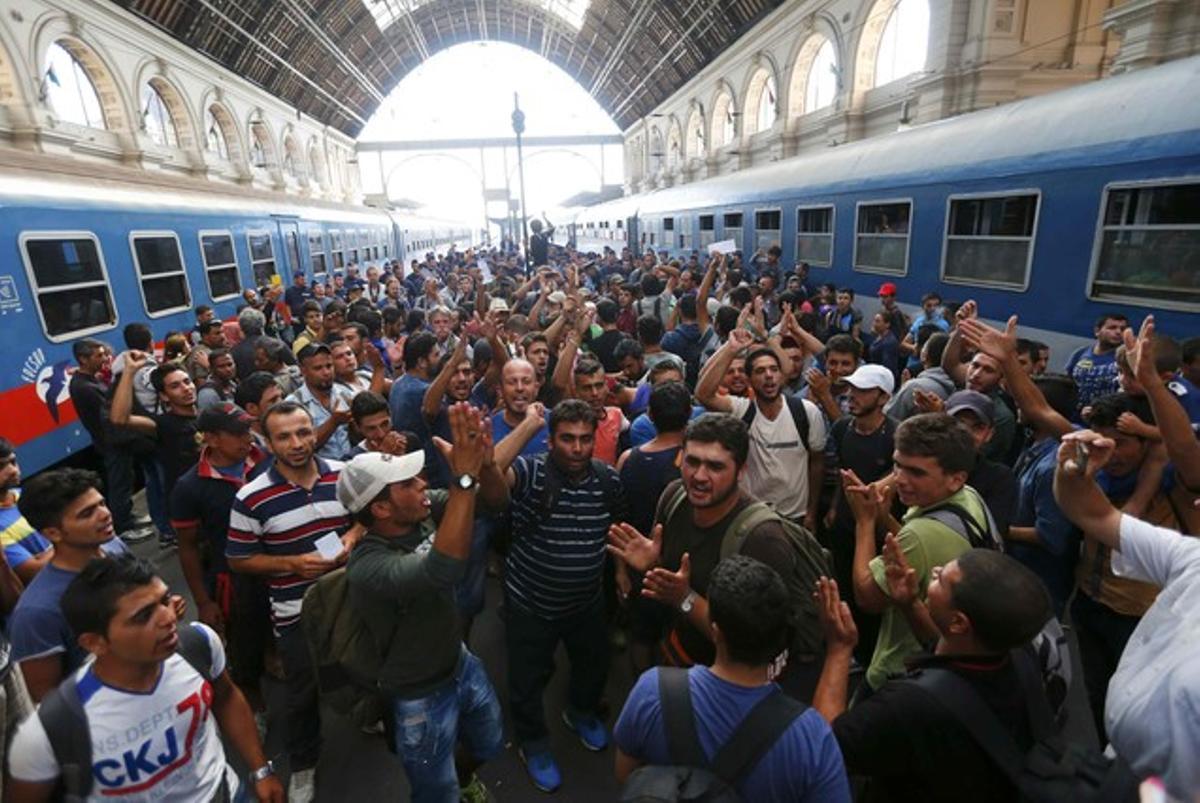 Los inmigrantes protestan al grito de Alemania, Alemania ante los agentes policiales que les cierran el pasoa la estación de trenes de Keleti, en Budapest.