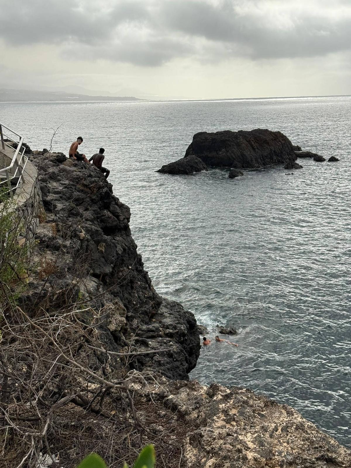 Menores se preparan para lanzarse al agua desde un risco en la zona entre La Puntilla y El Confital, en Las Palmas de Gran Canaria