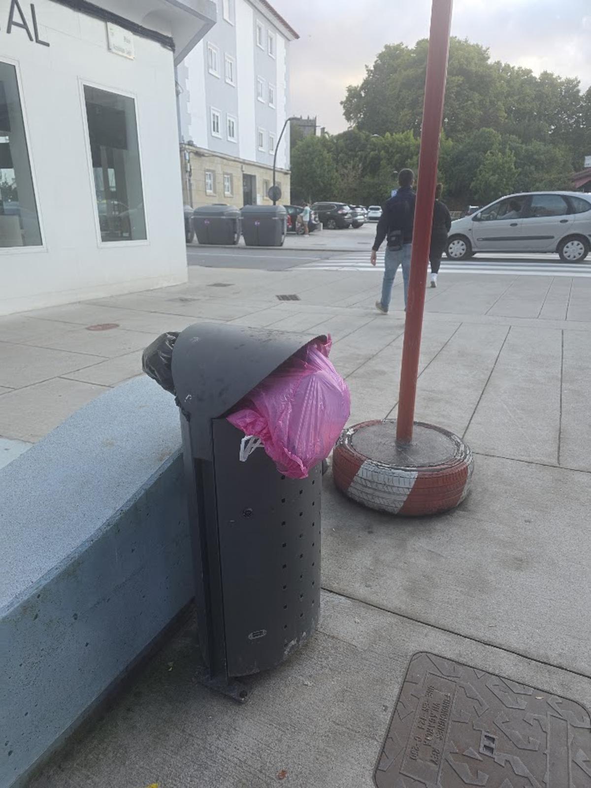 Bolsas de basura ocupando una papelera, a pesar de estar los contenedores al lado.