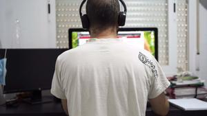 Un hombre teletrabaja desde el escritorio de su casa.