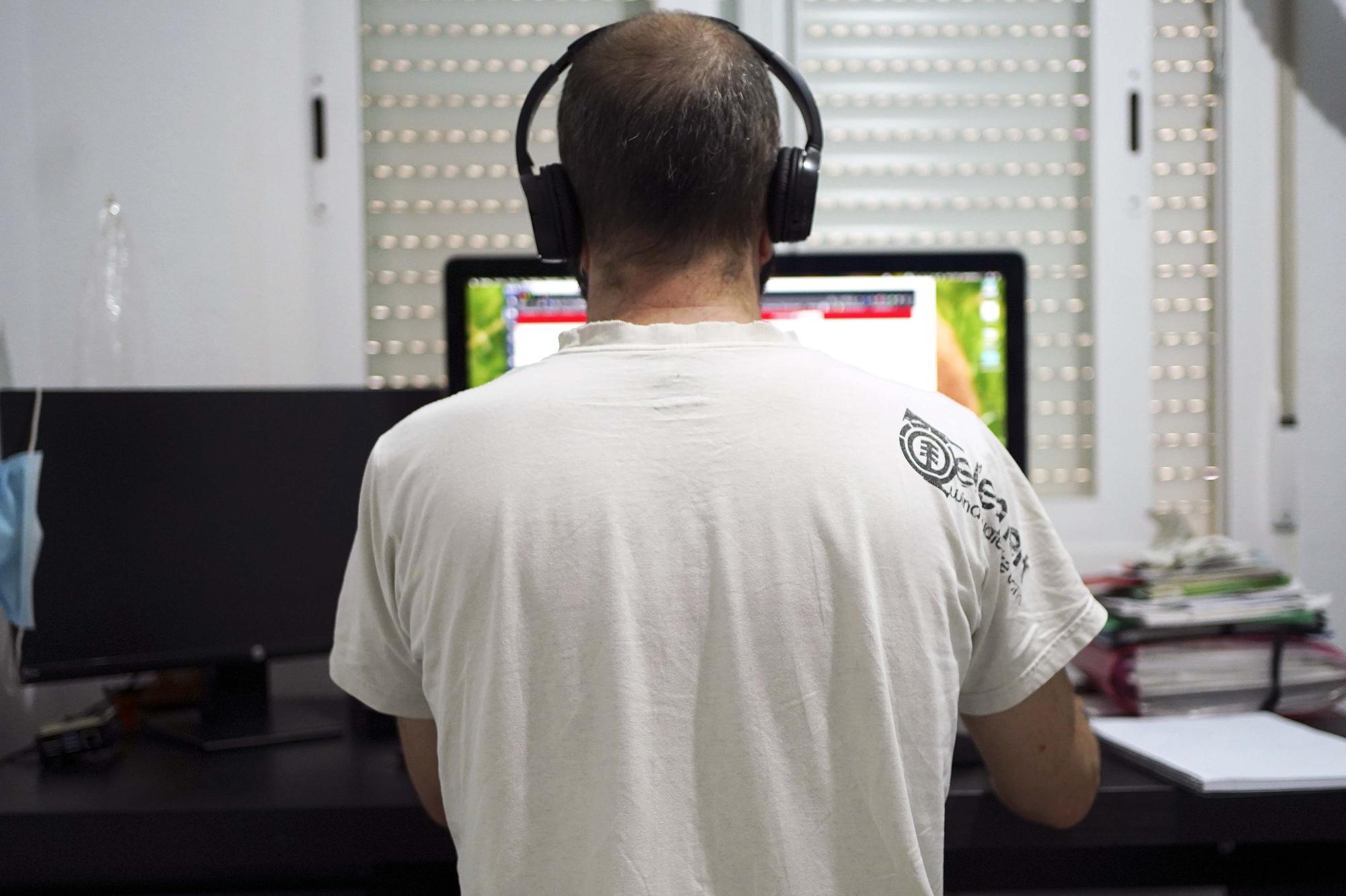 Un hombre teletrabaja desde el escritorio de su casa.