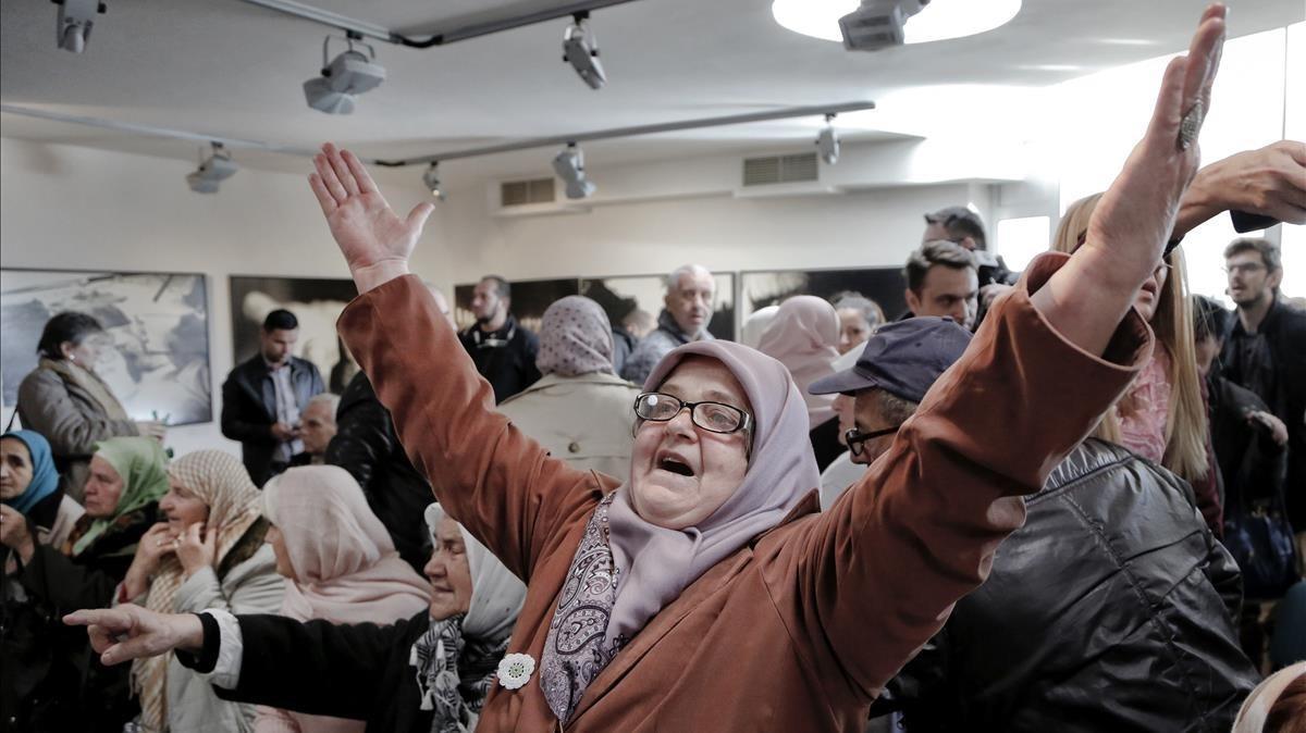 Una mujer bosnia levanta sus brazos en señal en señal de alegría al escuchar la sentencia en el centro conmemorativo en Potocari cerca de Srebrenica.