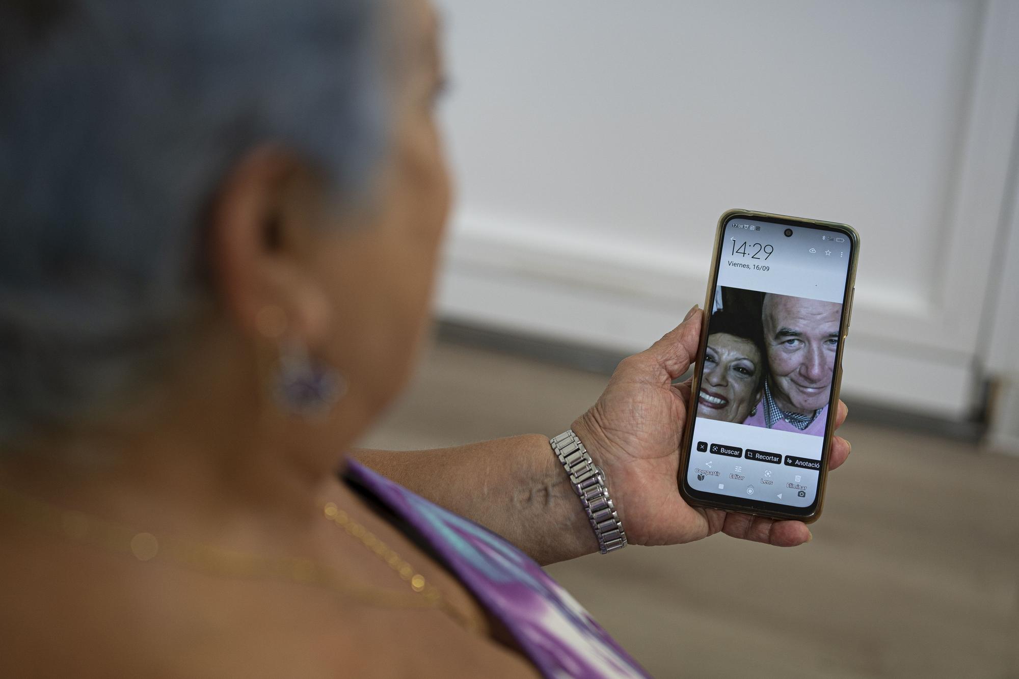 Isabel Gómez Suau muestra en el móvil una foto en la que aparece con José Carlos Valencia, su marido.