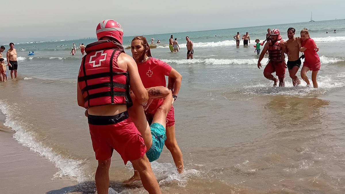 Miembros de Cruz Roja rescatan  a una persona en la playa del Cabanyal