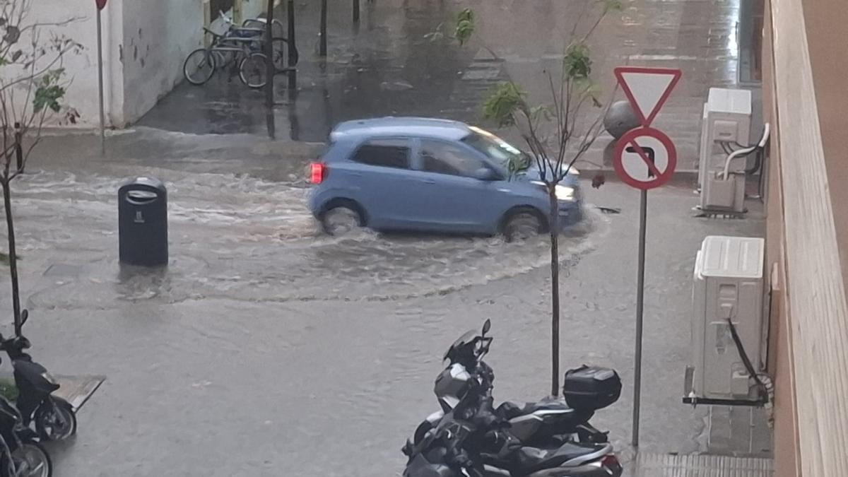 La calle Pere Francès inundada por la lluvia de este jueves