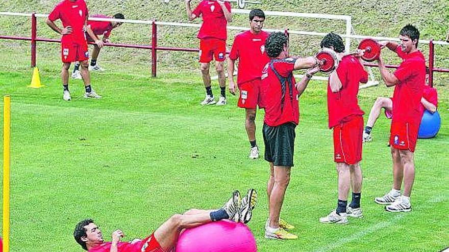 Los jugadores durante el circuito de fuerza y pesas. Miguel de la Cuevas, abajo, en un ejercicio con balón gigante.