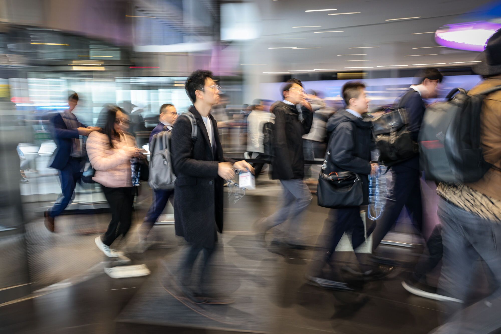 Gent entrant amb maletes i fent cua al MWC, en una imatge en velocitat
