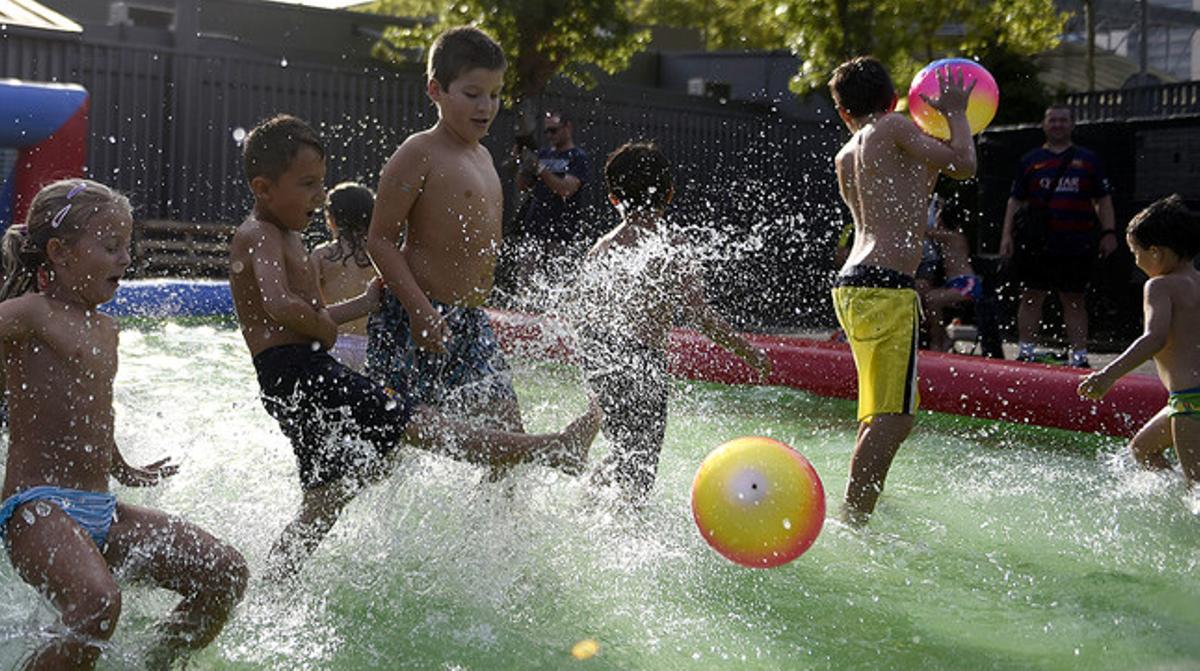 Un grupo de niños juegan al fútbol en una piscina inflable.