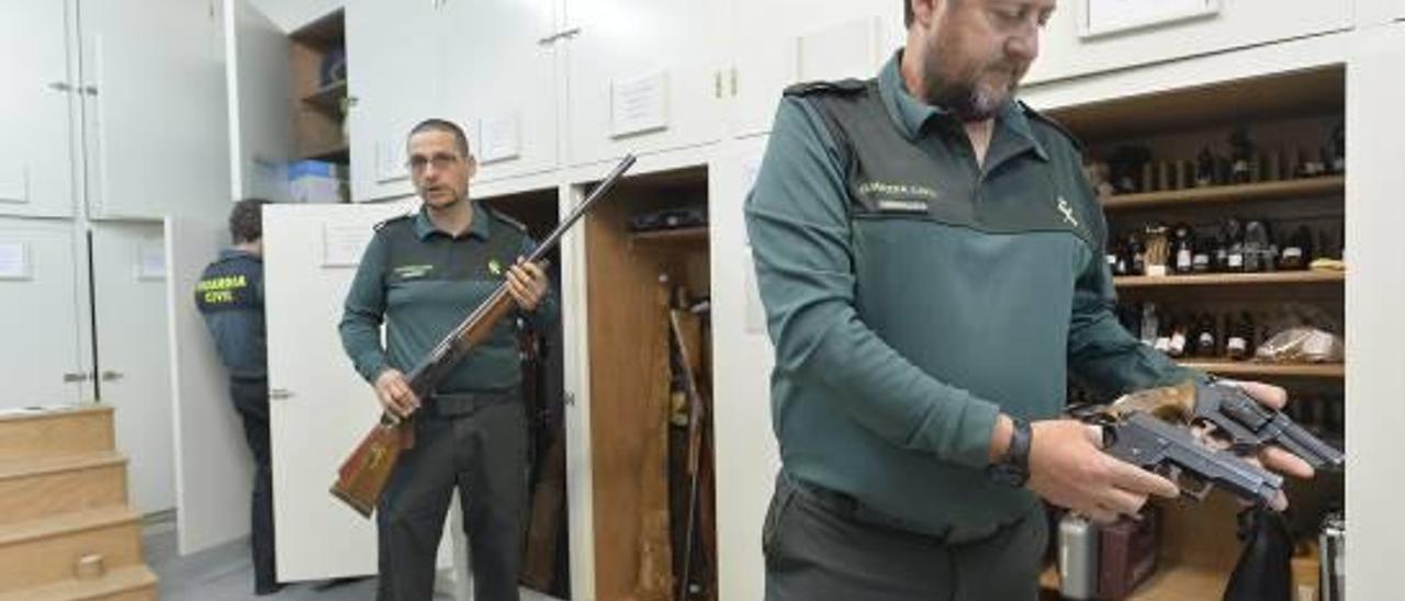 Agentes de la oficina de Intervención de Armas de la Guardia Civil de Elche con armas depositadas en el cuartel por órdenes judiciales.